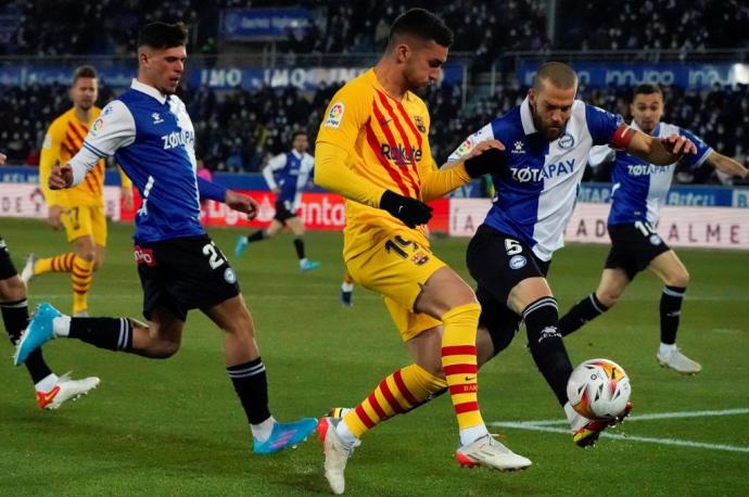 El delantero del FC Barcelona Ferrán Torres (2d) lucha con Víctor Laguardia, del Deportivo Alavés, durante el partido de la jornada 22 de la LaLiga Santander que se disputa hoy domingo en el estadio de Mendizorroza, en Vitoria.