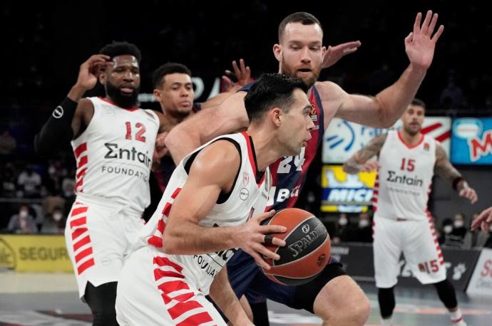 El ala-pívot estadounidense del Baskonia Matt Costello (detrás) presiona al base griego del Olympiacos Kostas Sloukas (primer plano) durante el partido de la Euroliga disputadoen el pabellón Fernando Bues