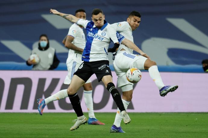 El centrocampista del Alavés, Edgar Méndez (i), disputa el balón ante el centrocampista brasileño del Real Madrid, Carlos Henrique Casemiro, durante el encuentro correspondiente a la jornada 25 de primera división que disputan hoy sábado en el estadio San