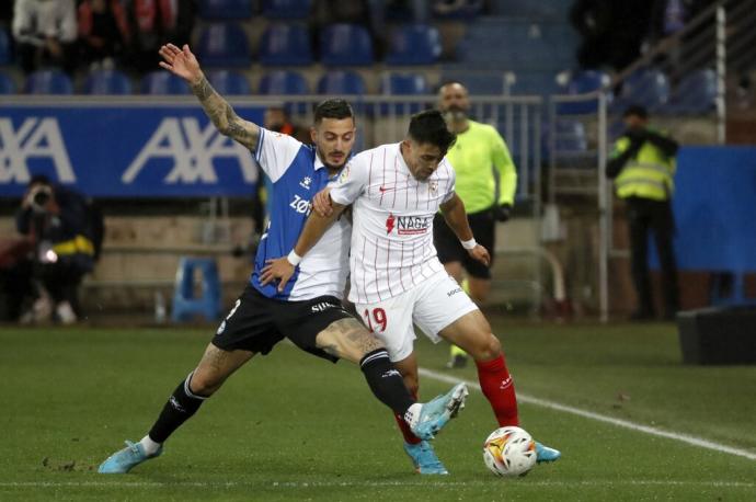 El delantero del Deportivo Alavés Joselu (i) lucha con el argentino Marcos Acuña, del Sevilla FC, durante el encuentro de la jornada 27 de Liga en Primera División que se juega hoy viernes en Mendizorroza, Vitoria.