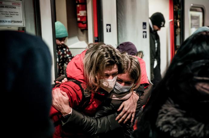 Una mujer abraza a una menor que llega en un tren a la estación central de Berlín.