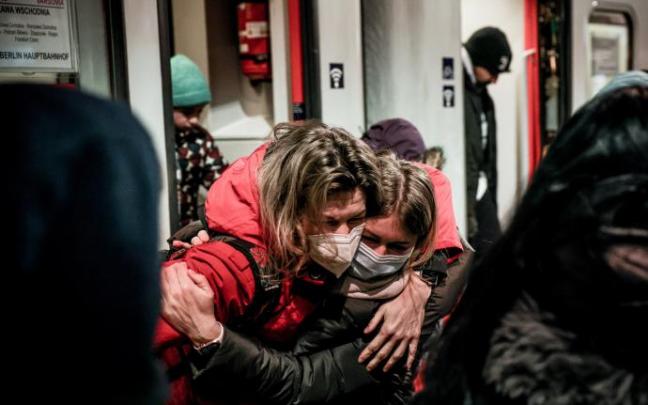 Una mujer abraza a una menor que llega en un tren a la estación central de Berlín.