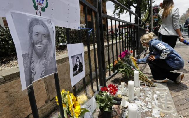 Seguidoras del grupo Foo Fighters encienden velas, frente al hotel de Bogotá donde falleció Taylor Hawkins.