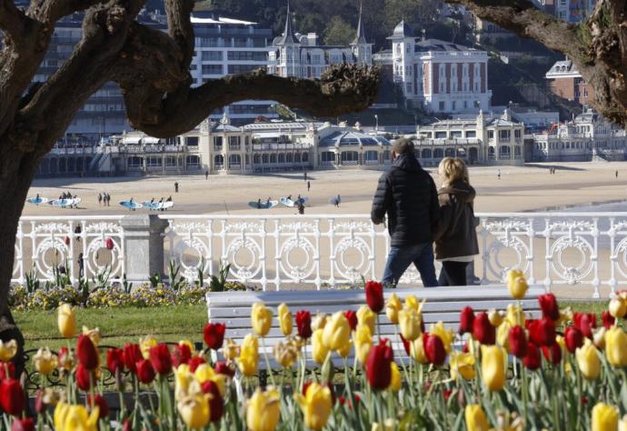 Dos personas aprovechan el buen tiempo para pasear por Donostia