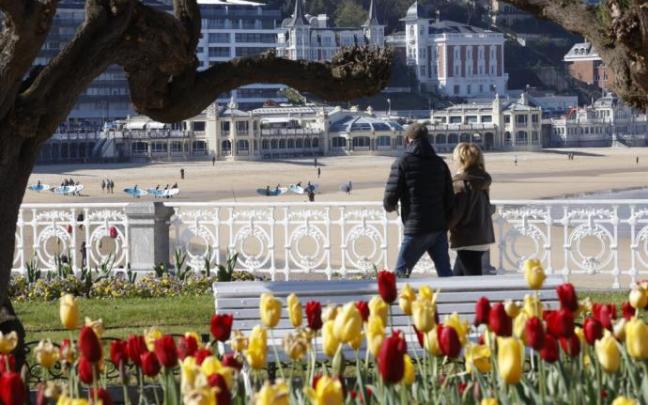 Dos personas aprovechan el buen tiempo para pasear por Donostia
