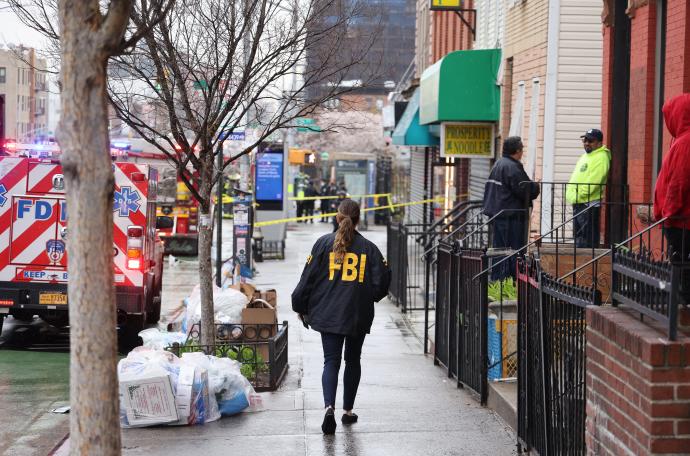 Un agente del FBI camina por la acera tras el tiroteo múltiple registrado en una estación de metro de Nueva York.