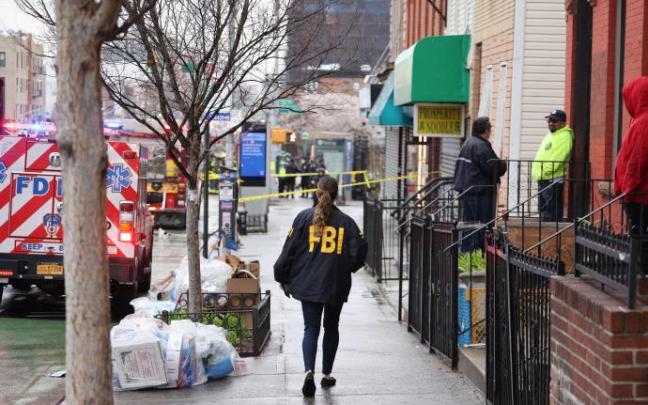 Un agente del FBI camina por la acera tras el tiroteo múltiple registrado en una estación de metro de Nueva York.