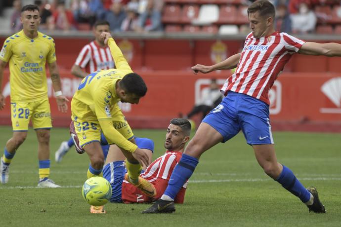 El centrocampista de la UD Las Palmas, Robert Rodriguez (i), intent llevarse el balón ante los jugadores del Sporting de Gijón