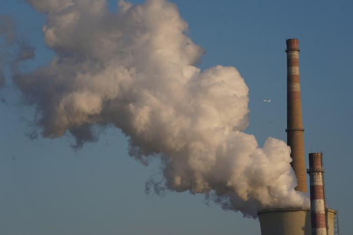 Una columna de humo se eleva desde la torre de una planta de energía.