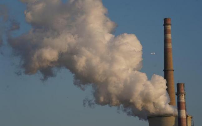 Una columna de humo se eleva desde la torre de una planta de energía.