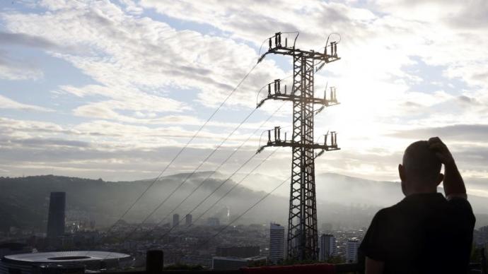 Una persona ante un poste de tendido eléctrico en Bilbao