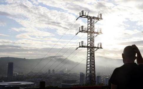 Una persona ante un poste de tendido eléctrico en Bilbao