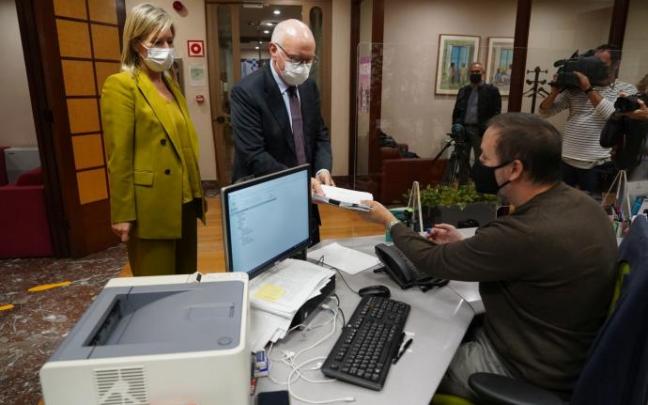 Ana Otadui, la presidenta de Juntas Generales, observa al diputado de Hacienda y Finanzas, José María Iruarrizaga, en el momento que registra los presupuestos 2022 en la secretaría de la Cámara vizcaina