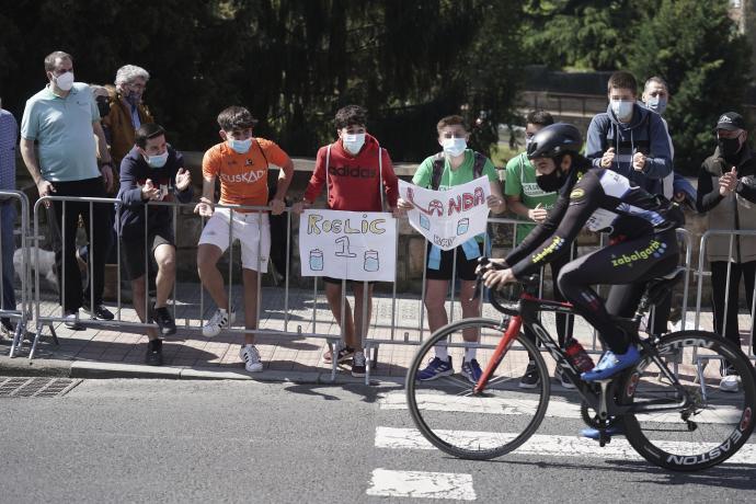 Varios jóvenes animan a un ciclista durante la primera etapa de la Itzulia 2021.