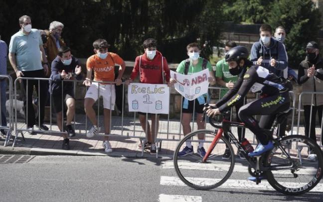 Varios jóvenes animan a un ciclista durante la primera etapa de la Itzulia 2021.