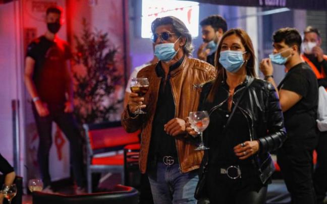 Varias personas en un una zona de bares.