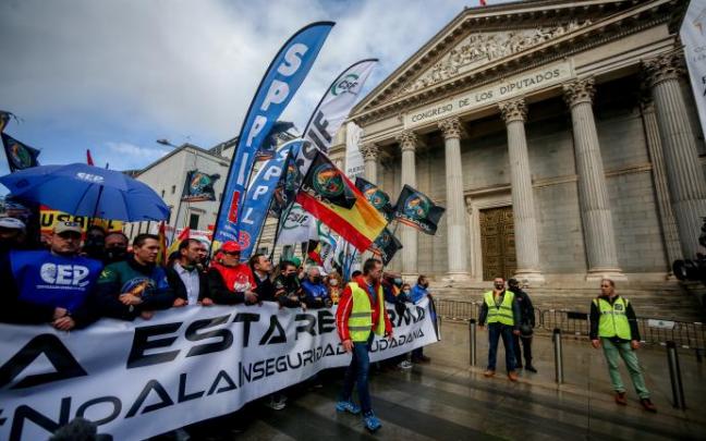 Varias personas sostienen una pancarta donde se lee "No a esta reforma" frente al Congreso de los Diputados.