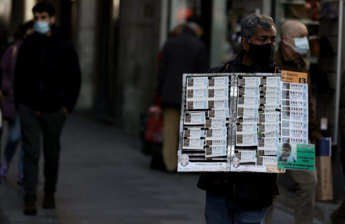 Un vendedor ambulante de lotería de Madrid apura las últimas horas para ofrecer décimos a compradores que van con retraso.