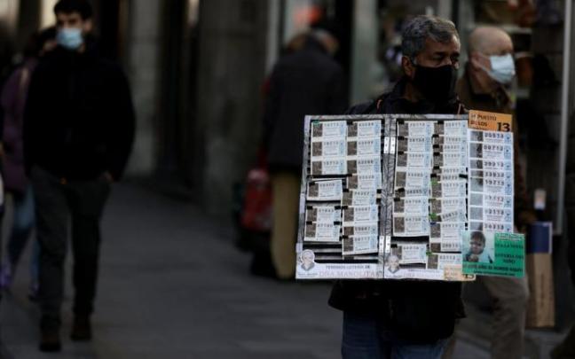 Un vendedor ambulante de lotería de Madrid apura las últimas horas para ofrecer décimos a compradores que van con retraso. Un vendedor ambulante de lotería de Madrid apura las últimas horas para ofrecer décimos a compradores que van con retraso.