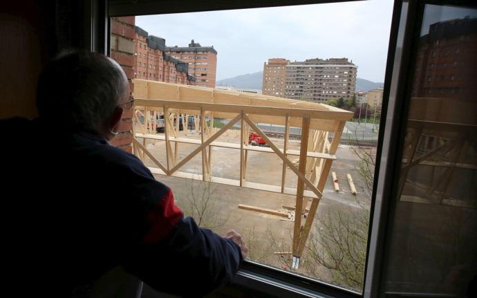 Un vecino observa desde su domicilio el aspecto de la nueva cubierta para el patio.