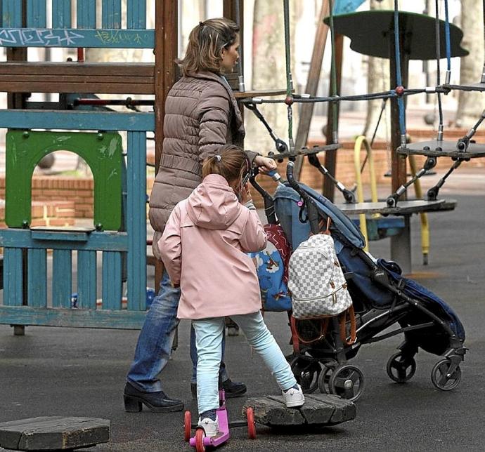 Una mujer en un parque cuidando de sus hijos. Foto: Josu Chavarri