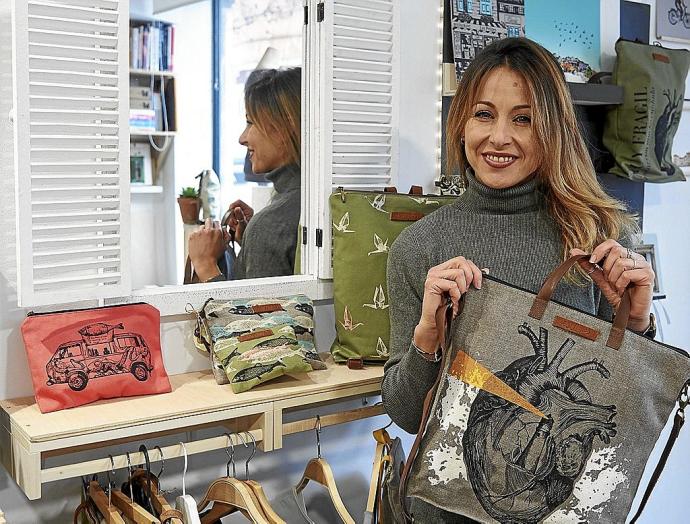 María García Fernández posa con un bolso con un corazón ilustrado en el interior de su estudio creativo Escamas en la calle Tajonar de Pamplona.