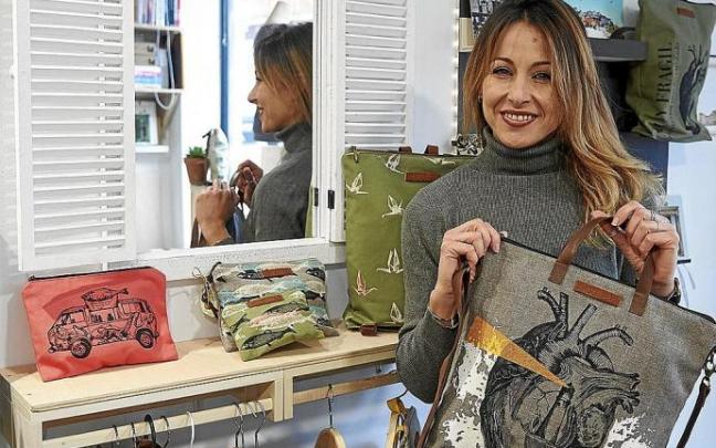 María García Fernández posa con un bolso con un corazón ilustrado en el interior de su estudio creativo Escamas en la calle Tajonar de Pamplona.