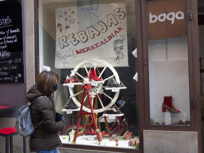 Una mujer observa un escaparate de una tienda de Vitoria.