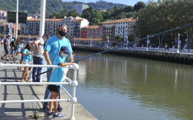 Un padre acompaña a su hijo que participa en la Escuela de Pesca Gran Ría de Bilbao en el muelle de Ripa. Un padre acompaña a su hijo que participa en la Escuela de Pesca Gran Ría de Bilbao en el muelle de Ripa.