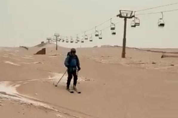 El joven, esquiando sobre la nieve cubierta de polvo marrón.