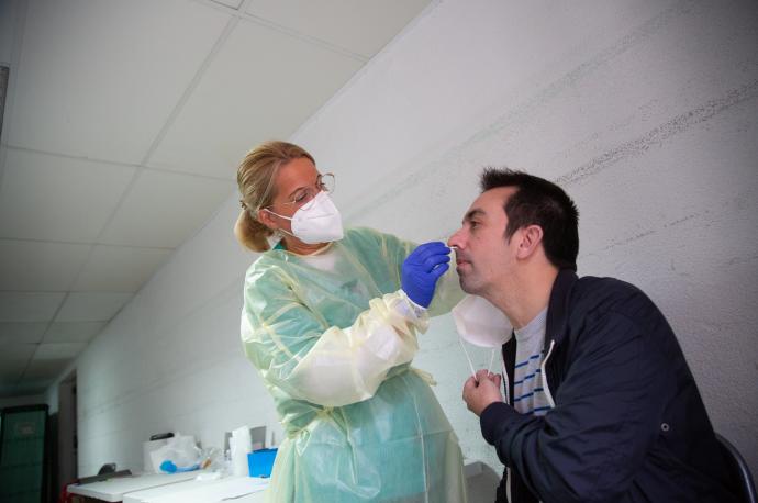 Una sanitaria realiza un test de antígenos o una PCR a un hombre, en un dispositivo de cribado masivo en Badajoz.