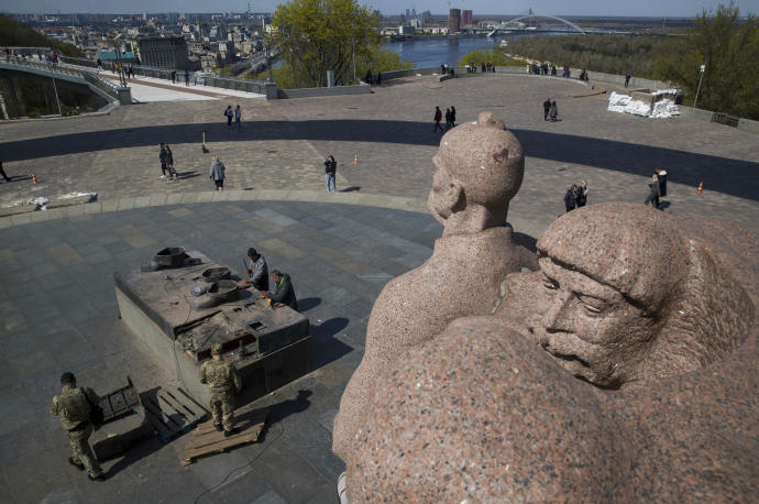 Trabajadores desmontando una estatua conmemorativa de la amistad entre Ucrania y Rusia en el centro de Kiev