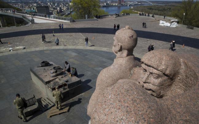 Trabajadores desmontando una estatua conmemorativa de la amistad entre Ucrania y Rusia en el centro de Kiev