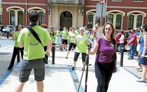 Aisha Montero con el bastón de peregrina seguida de la batucada Batukartean en el ayuntamiento.