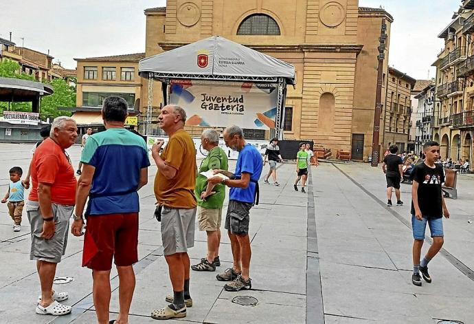 Un grupo de peregrinos observa el escenario de la plaza de los Fueros por la tarde.