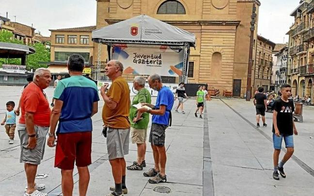 Un grupo de peregrinos observa el escenario de la plaza de los Fueros por la tarde.