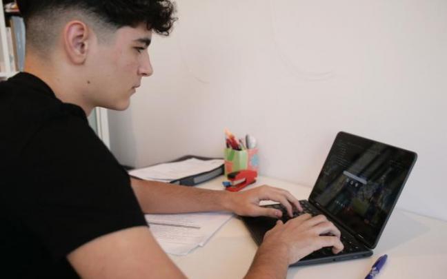 Un joven trabaja con su ordenador desde casa.