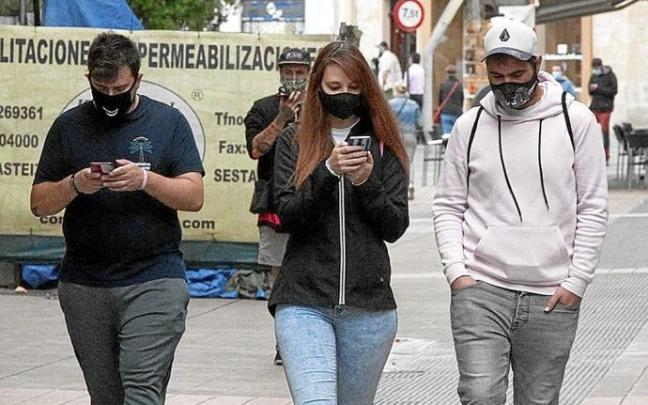 Hiriko erdigunetik mugikorrekin ibiltzen ari diren gazte batzuen irudia. Argazkiak: Josu Chavarri