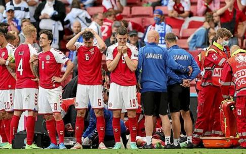 Eriksen, consciente, abandona el Parken Stadion.