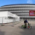 Un ciclista pasa por delante de los preparativos de la Eurocopa en la explanada de San Mamés.