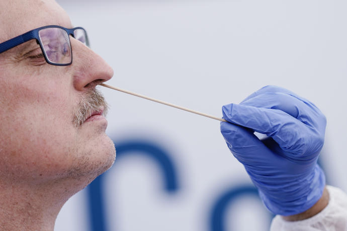 Un trabajador médico toma una muestra de un hombre en una clínica móvil de coronavirus en Mannheim (Alemania).
