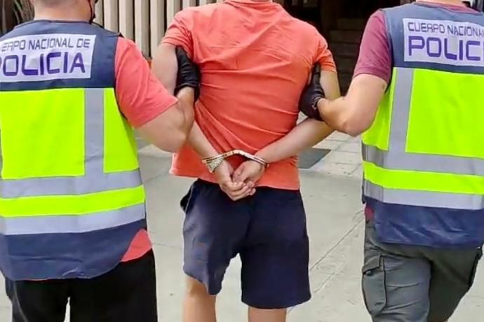 Dos agentes de la Policía Nacional acompañan a un detenido.