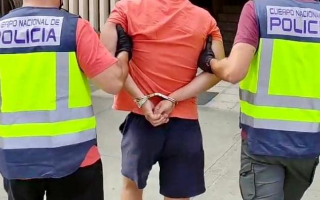 Dos agentes de la Policía Nacional acompañan a un detenido. Dos agentes de la Policía Nacional acompañan a un detenido.