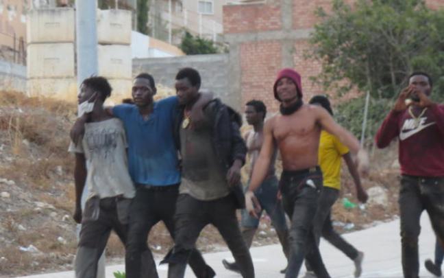 Migrantes de origen subsahariano tras saltar la valla el pasado mes de julio Migrantes de origen subsahariano tras saltar la valla el pasado mes de julio