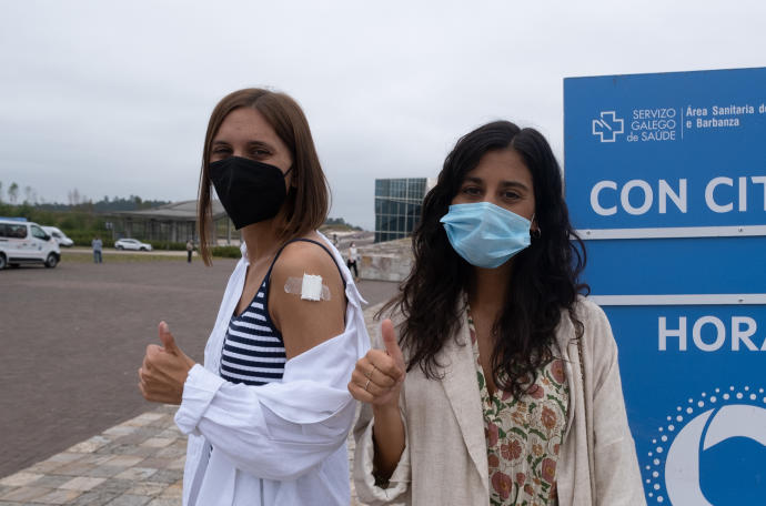 Dos jóvenes saludan tras ser vacunadas contra el Covid-19 en Santiago de Compostela, Galicia.