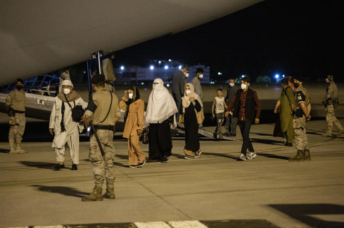 Varias personas repatriadas llegan a la pista tras bajarse del avión A400M en el que ha sido evacuados de Kabul.