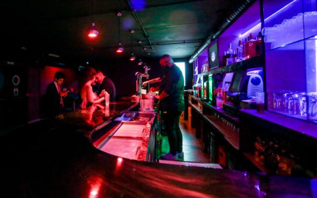 Varias personas en la barra de una discoteca.