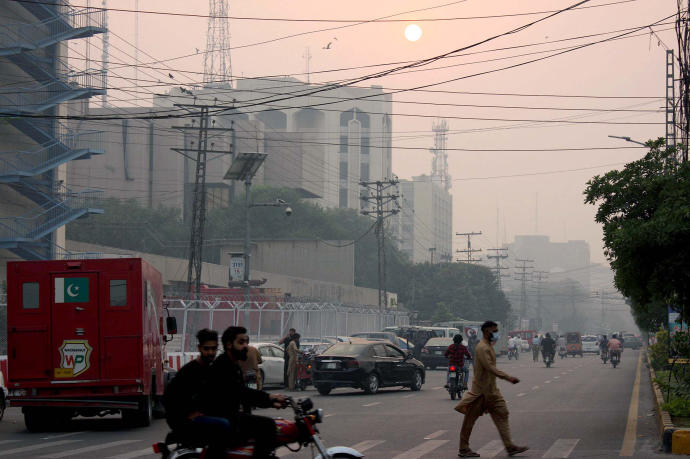 Varios peatones caminan por una calle de Pakistán.