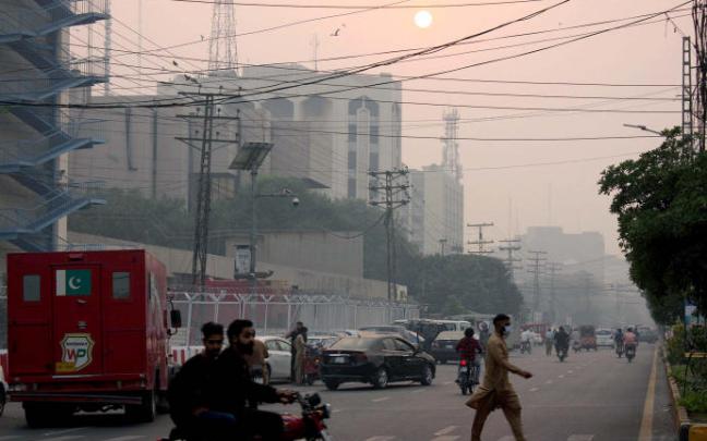Varios peatones caminan por una calle de Pakistán.