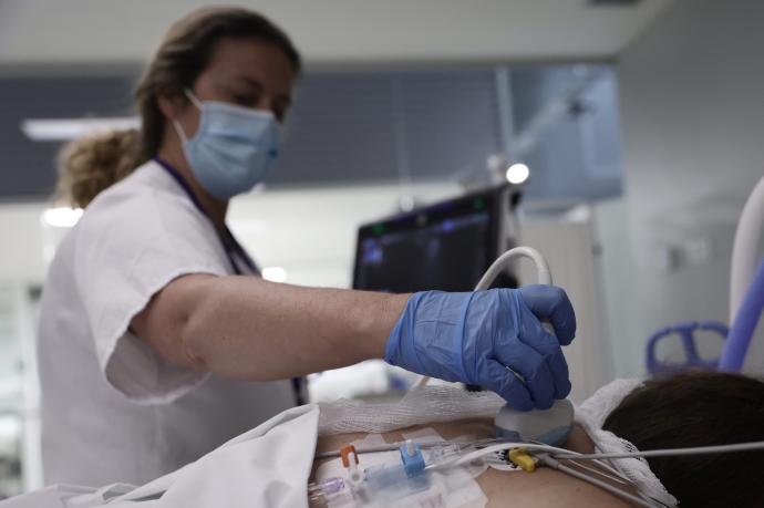 Una sanitaria realiza una ecografía a una paciente en la UCI.